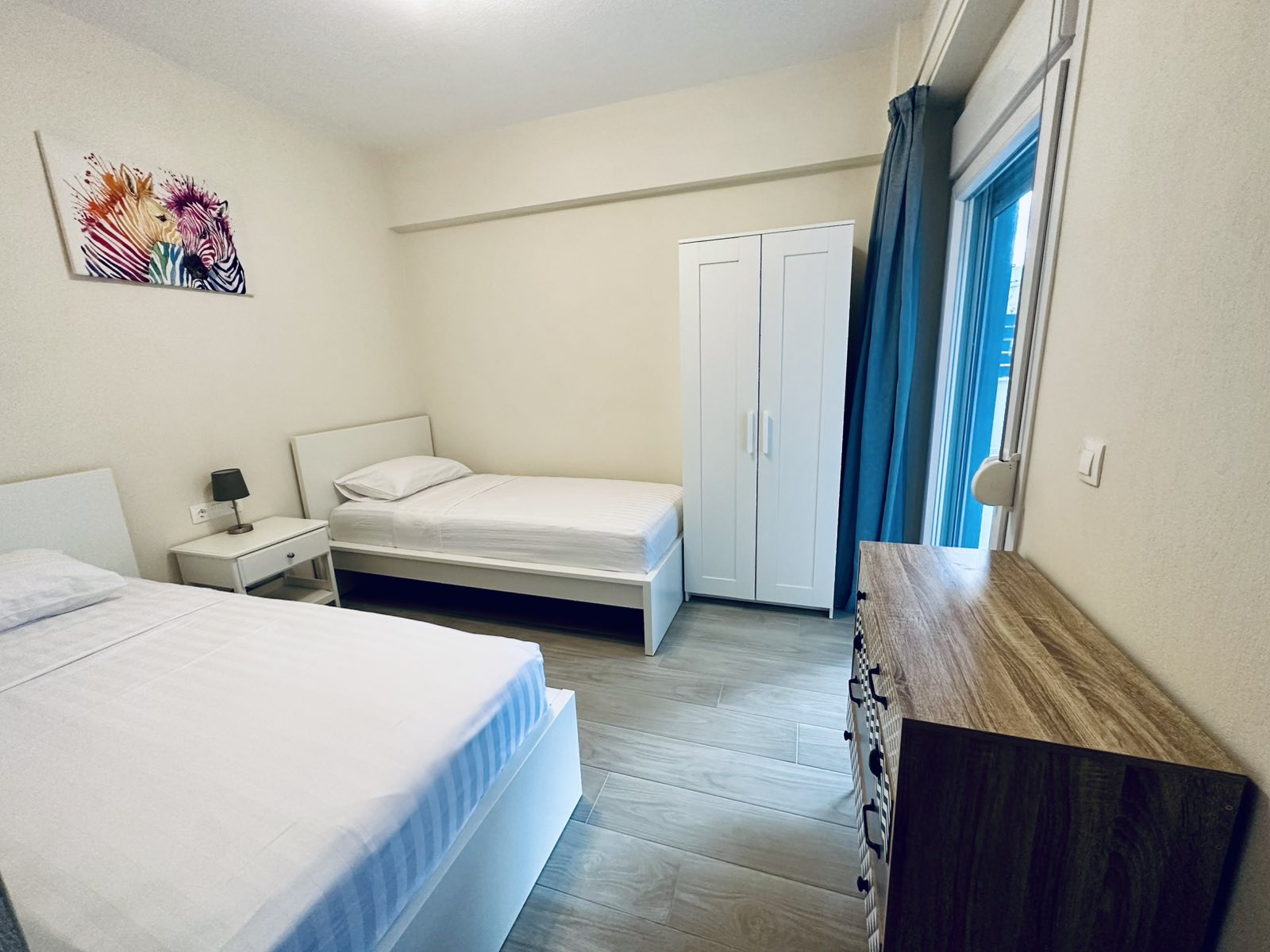 Bedroom 2 with two single beds, wardrobe and chest of drawers at Lora Family Apartment